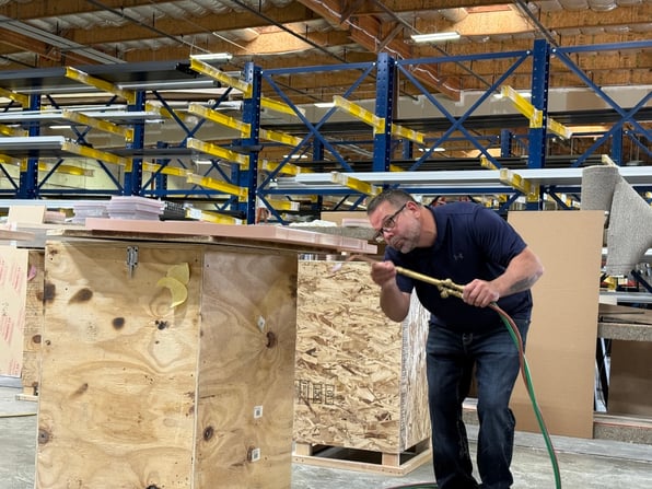 A TSS employee works on a ballistic panel, demonstrating how manufacturing materials in the United States can reduce supply chain uncertainty and improve budgeting for building security projects.