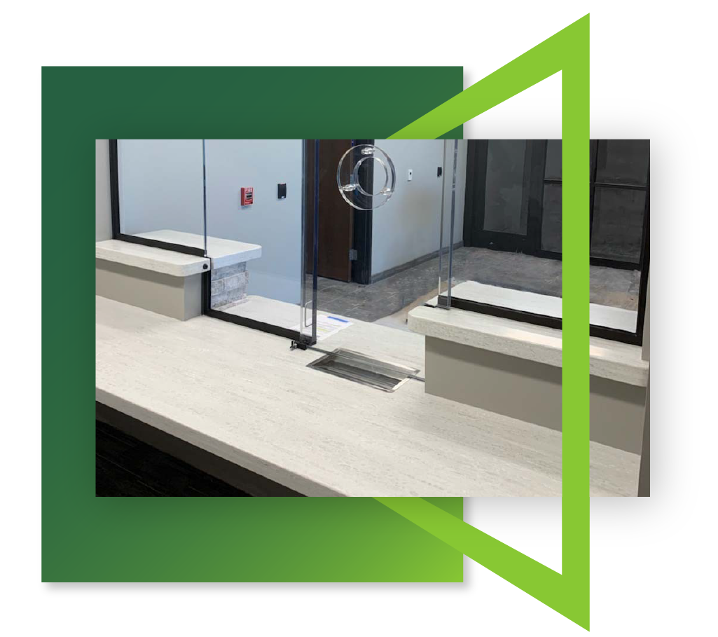 A photo showing a ballistic counter outfitted with a currency tray as well as a talk-thru system in a high-traffic area